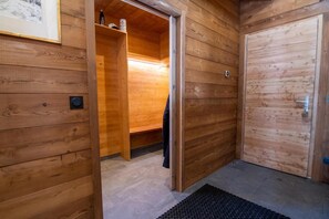 A wooden interior with a bench, a door, and a small shelf with items. - Chalet, fitness, sauna, terrace, balcony, 200m², Valloire (Valloire)