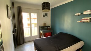 Ein Schlafzimmer mit einem Bett, einem Schreibtisch und einem Bücherregal.