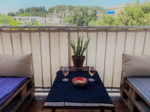 A balcony with a table set for two, featuring a potted plant, two wine glasses, and a bowl of snacks. - Very nice T4 +terrace, near town center, free parking (Aix-en-Provence)