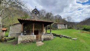 Une chapelle en pierre dotée d’un clocher, entourée d’une pelouse et d’arbres.