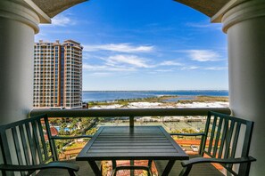 Ein Balkon mit Blick auf einen Strand und ein hohes Hotelgebäude.