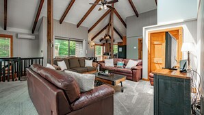 A spacious living room with leather sofas, a wooden coffee table, and a ceiling fan. - Dog Friendly Luxury Estate w/ Hot Tub & Dock (Oakland)
