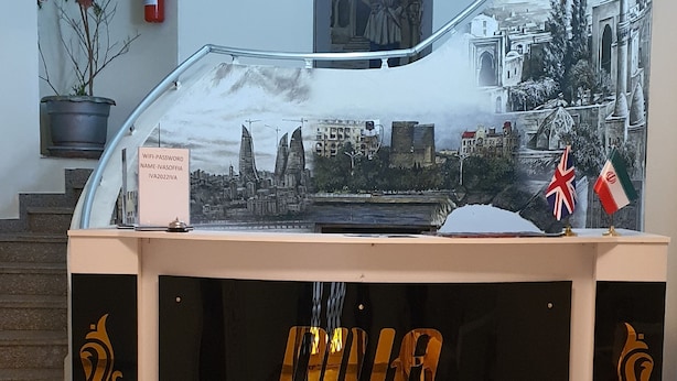A reception desk with clocks displaying times from London, Istanbul, Baku, Moscow, and Dubai. - Diva Hotel (Baku)