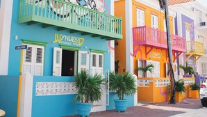 Un edificio colorido con un letrero de hotel boutique, balcones y plantas en macetas.