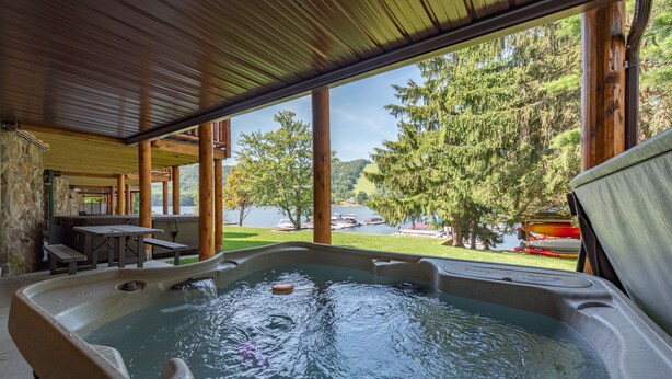 A hot tub with a view of a lake and trees.
