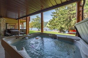Un jacuzzi con vistas a un lago y árboles.