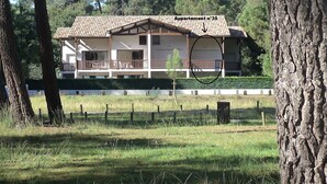 A two-story house with a balcony, surrounded by trees and a fence. - Duplex 4 pers lakeside, beach and bike path (biscarrosse)