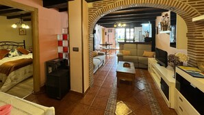 Ein gemütliches Wohnzimmer mit Kamin, einer Couch, einem Couchtisch und einem Fernseher.