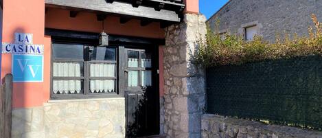A building with a stone facade, a wooden balcony, and a sign reading "LA CASINA."