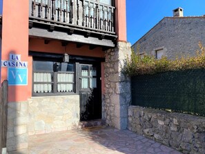 A building with a stone facade, a wooden balcony, and a sign reading "LA CASINA."