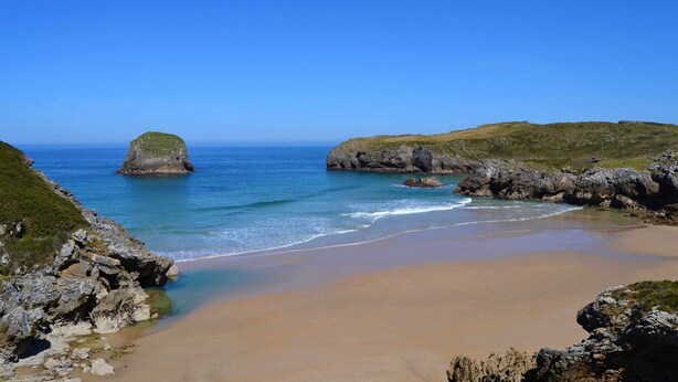 A coastal beach with rocky outcrops and clear blue water. - House (Llanes)