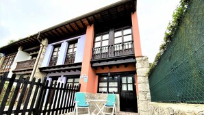 A building with a stone facade, a wooden fence, and a sign reading "LA CASINA." - House (Llanes)
