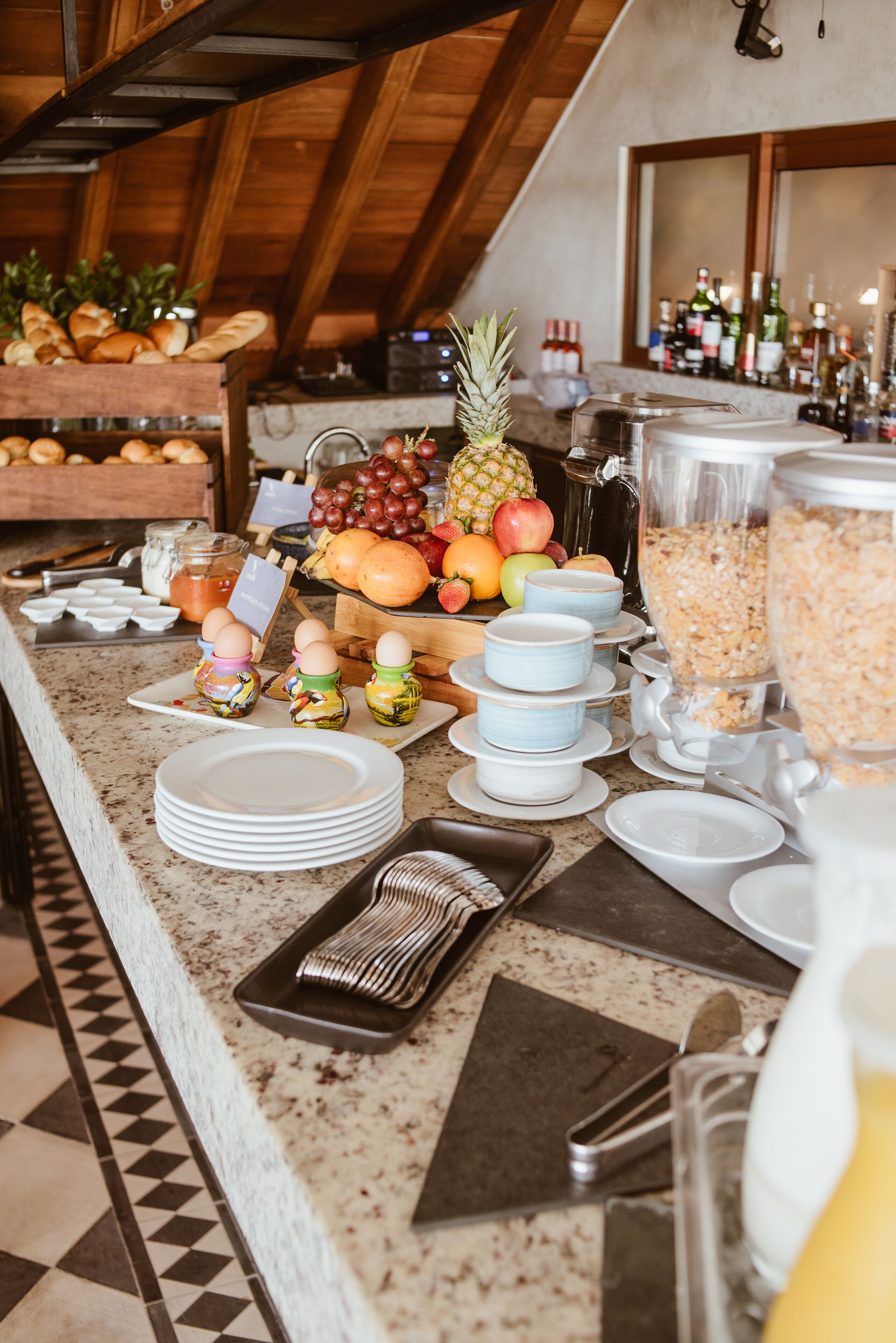 A breakfast buffet with various fruits, pastries, and beverages.