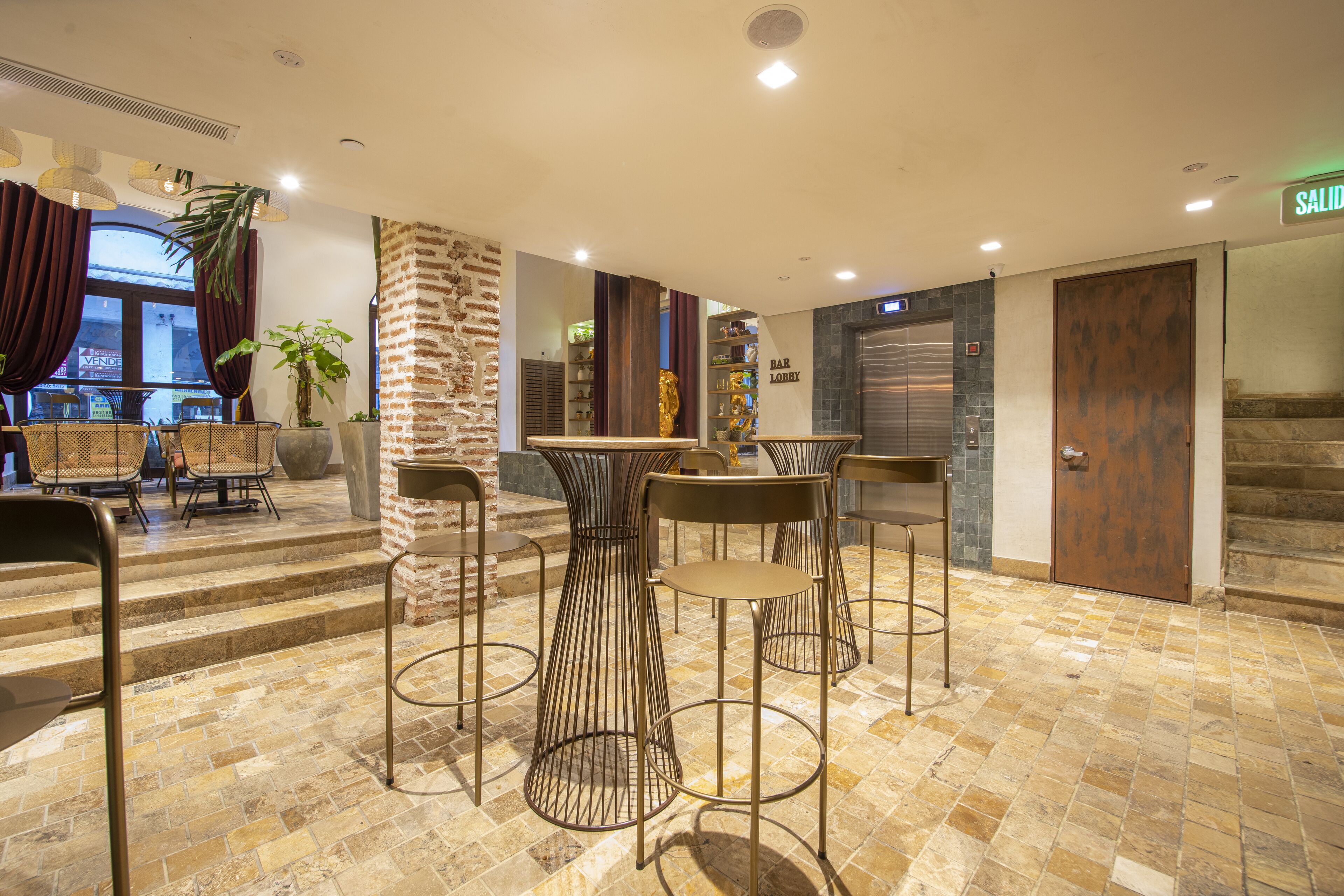 Eine moderne Lobby mit Barbereich, Sitzgelegenheiten und einer Treppe.