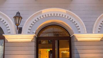 Un bâtiment doté d’une entrée imposante, avec une porte en arc de cercle et un balcon orné de balustrades.