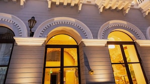 A building with multiple balconies and arched windows, illuminated by warm lighting. - Hotel Voilá Centro Histórico (Cartagena)