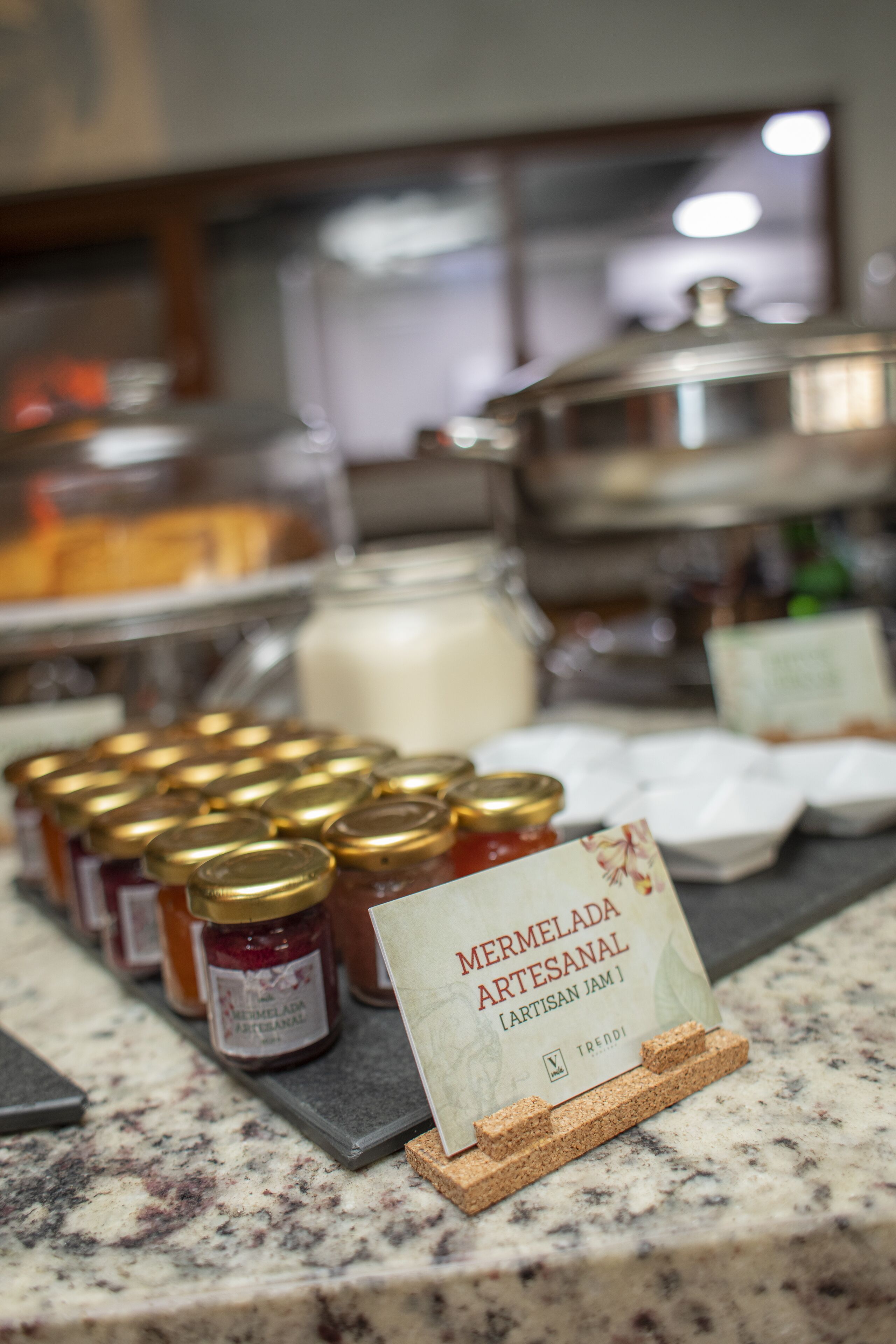 Een presentatie van marmelade potten en een bordje met de tekst 'Mermelada Artesanal [Artisan Jam]'.