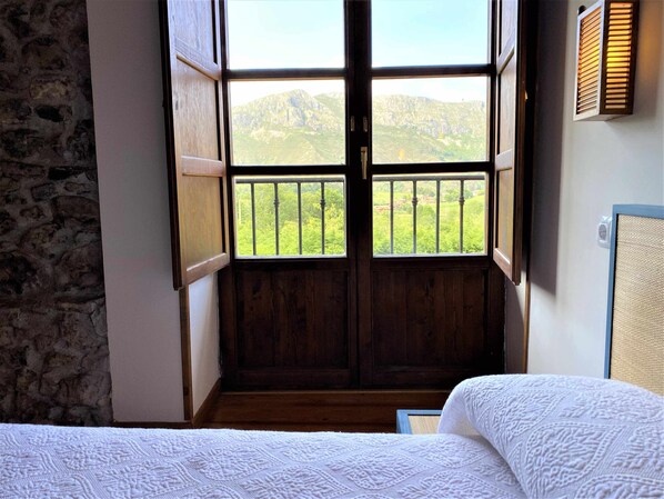 A room with a wooden door leading to a balcony with a mountain view. - La Casina de Orfeo Bowl Cangas de Onís VV-1901-A (Cuenco)