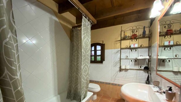 A bathroom with a bathtub, toilet, and sink.