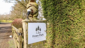 A sign for Fram Park with a wooden statue and a microphone. - Alwinton Lodge (Morpeth)