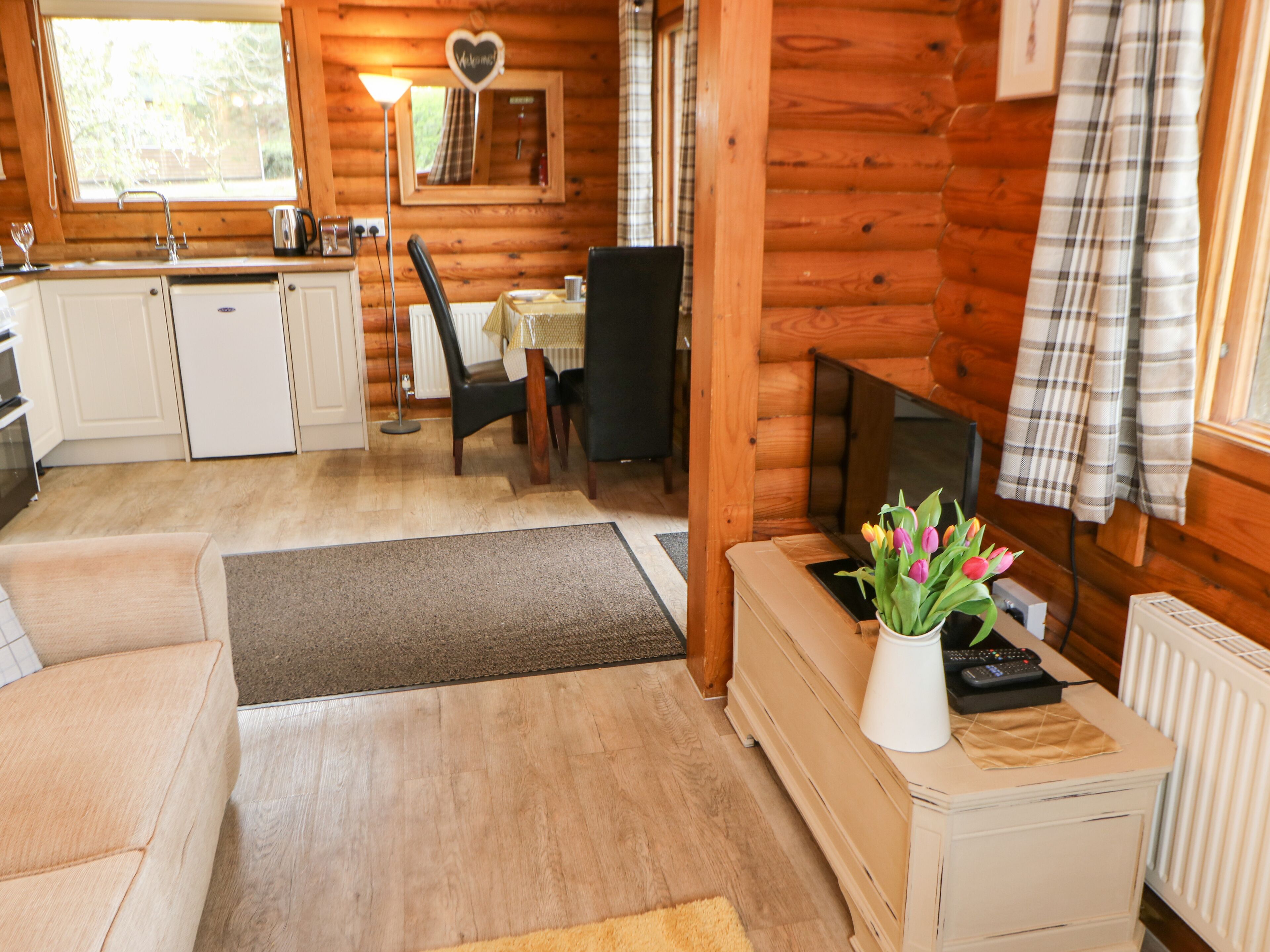A cozy cabin interior with a kitchenette, dining area, and seating space.