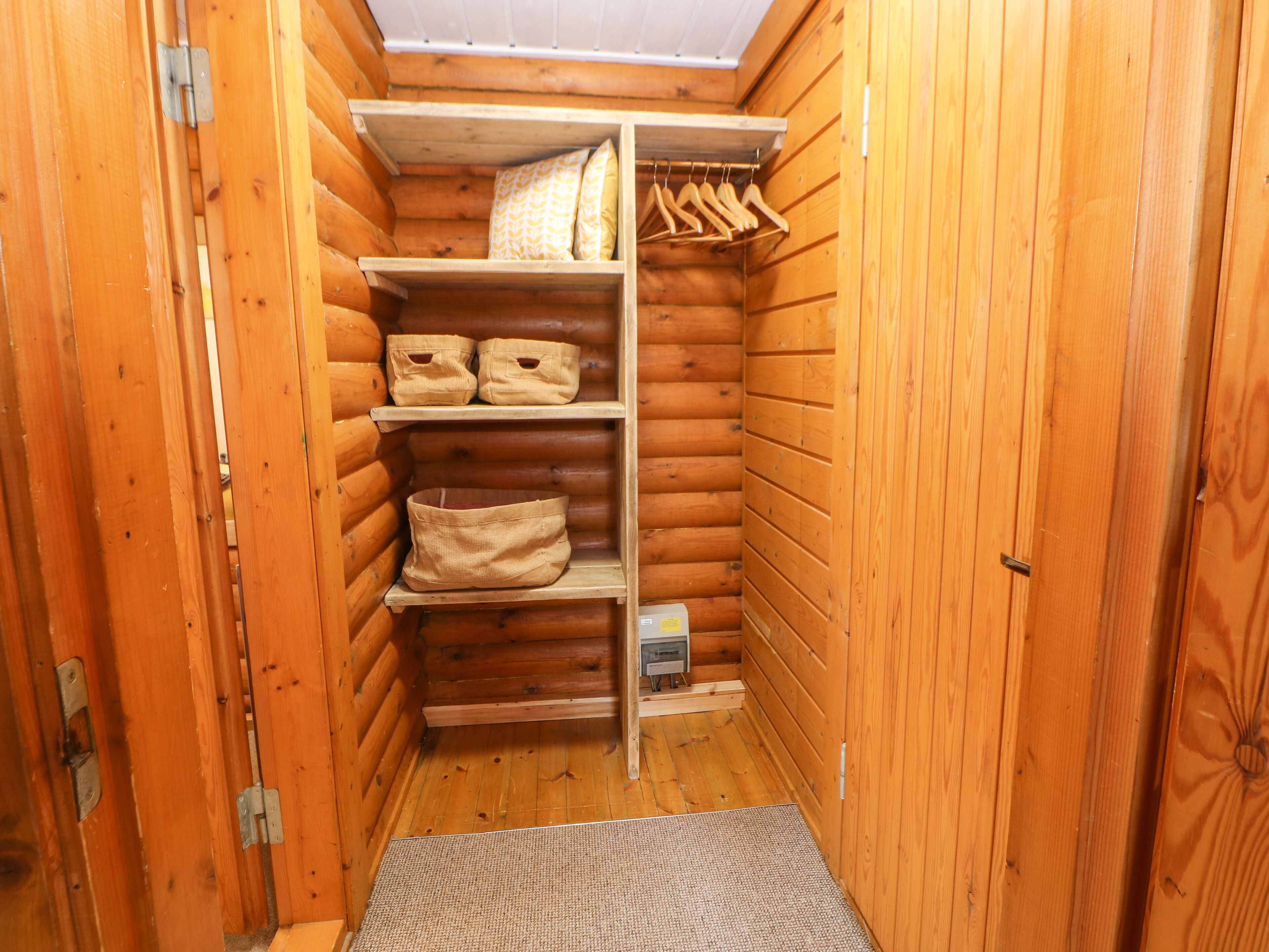 Un armario de madera compacto con estantes, espacio para colgar y un pequeño compartimento.