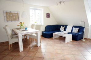 Un salon comprenant une table à manger, deux canapés et une table basse.