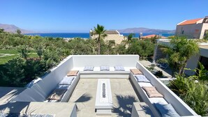 A rooftop terrace with a central fire pit, surrounded by seating with cushions. - Villa Lydia ,two pools, indoor heated pool , sea view (Κίσσαμος)
