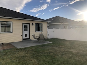 A residential house with a front porch, a white fence, and a lawn. - Glacier Park Whitefish Getaway - Comfy & Updated (Columbia Falls)