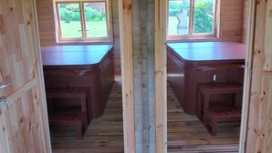 Une cabane en bois dotée de deux bains à remous, d’une terrasse en bois et offrant une vue sur le jardin.