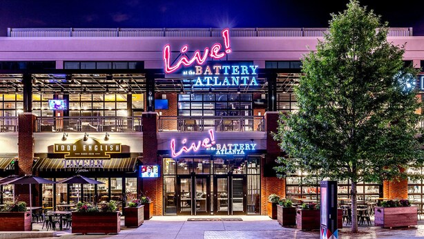 A building with a neon sign reading "Live! Battery Atlanta" and another sign for "Todd English at the Tavern".