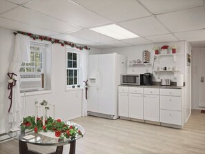 A compact kitchen with white cabinets, a microwave, and a refrigerator.