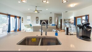A modern kitchen with a double sink, stainless steel appliances, and pendant lighting.