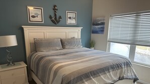 A bedroom with a bed, a nightstand, a lamp, and artwork on the wall. - Beautiful 3 Bedroom Condo in Barefoot Landing (North Myrtle Beach)