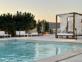 Una piscina al aire libre de temporada, sombrillas, tumbonas