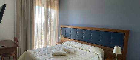 Una camera d'albergo con un letto, una scrivania e una sedia.