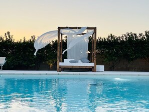 Een seizoensgebonden buitenzwembad, parasols voor strand/zwembad