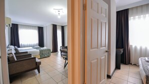 Ein Hotelzimmer mit Bett, Sofa, Sessel und einem kleinen Tisch.