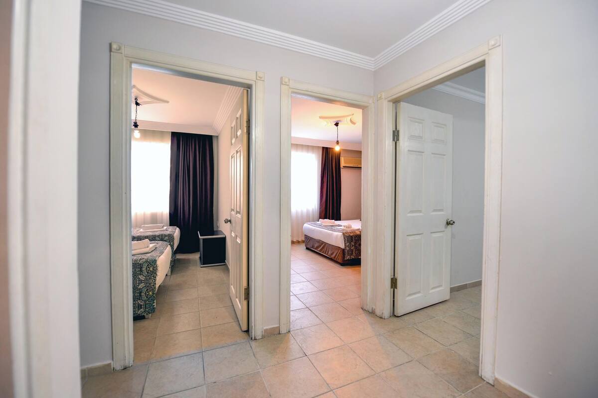 A hotel room with a bed, a small seating area with a sofa and chairs, and a bathroom with a shower and toilet.