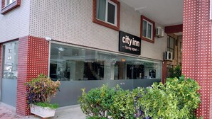 Ein City Inn Hotel mit moderner Fassade, großen Fenstern und einem Schild, das es als familienfreundlich kennzeichnet.
