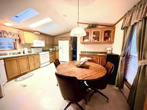 Enjoy meals together at the central dining table surrounded by four chairs.
