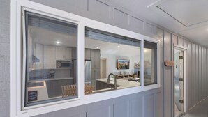 Uma cozinha moderna com uma janela ampla, uma área de refeições com mesa e cadeiras, e uma bancada central.