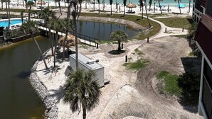 A beach resort with a pool, palm trees, and a view of the ocean. - Luxurious Penthouse condo @ Pointe Santo with magnificent ocean and garden views (Sanibel)
