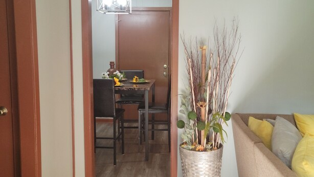 Una habitación con comedor, sofá y planta en maceta.