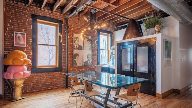 A modern kitchen with a glass table, wooden chairs, and a brick wall. - Historic KC Firehouse  #8 - 40 (Kansas City)
