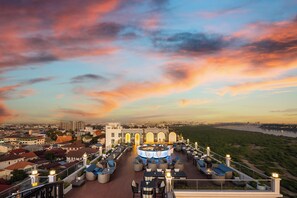 Terraza en la azotea con mobiliario exterior y vistas a la ciudad y al río.