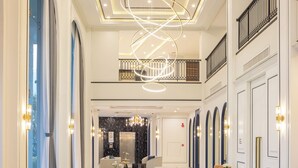 A spacious lobby with a central seating area, a modern chandelier, and a view to the elevator. - Eastin Hotel Vientiane Laos (Vientiane)