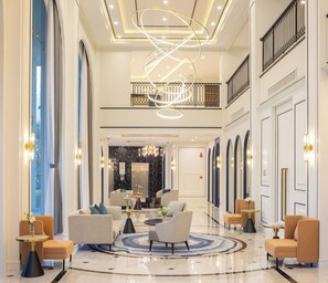 A spacious lobby with a central seating area, a modern chandelier, and a view to the elevator. - Eastin Hotel Vientiane Laos (Vientiane)
