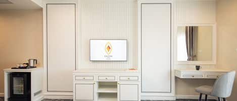 Habitación de hotel con cama, escritorio, tocador y logotipo enmarcado en la pared.