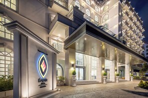 Ein prachtvoller Hotelzugang mit auffälligem Logo, großen Glasüren und einer gut beleuchteten Fassade.